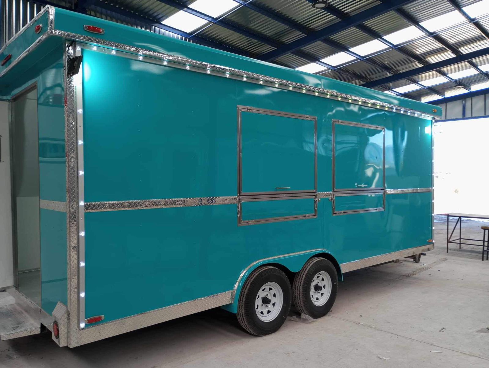 Blue food trailer illuminated with LED lighting at dusk