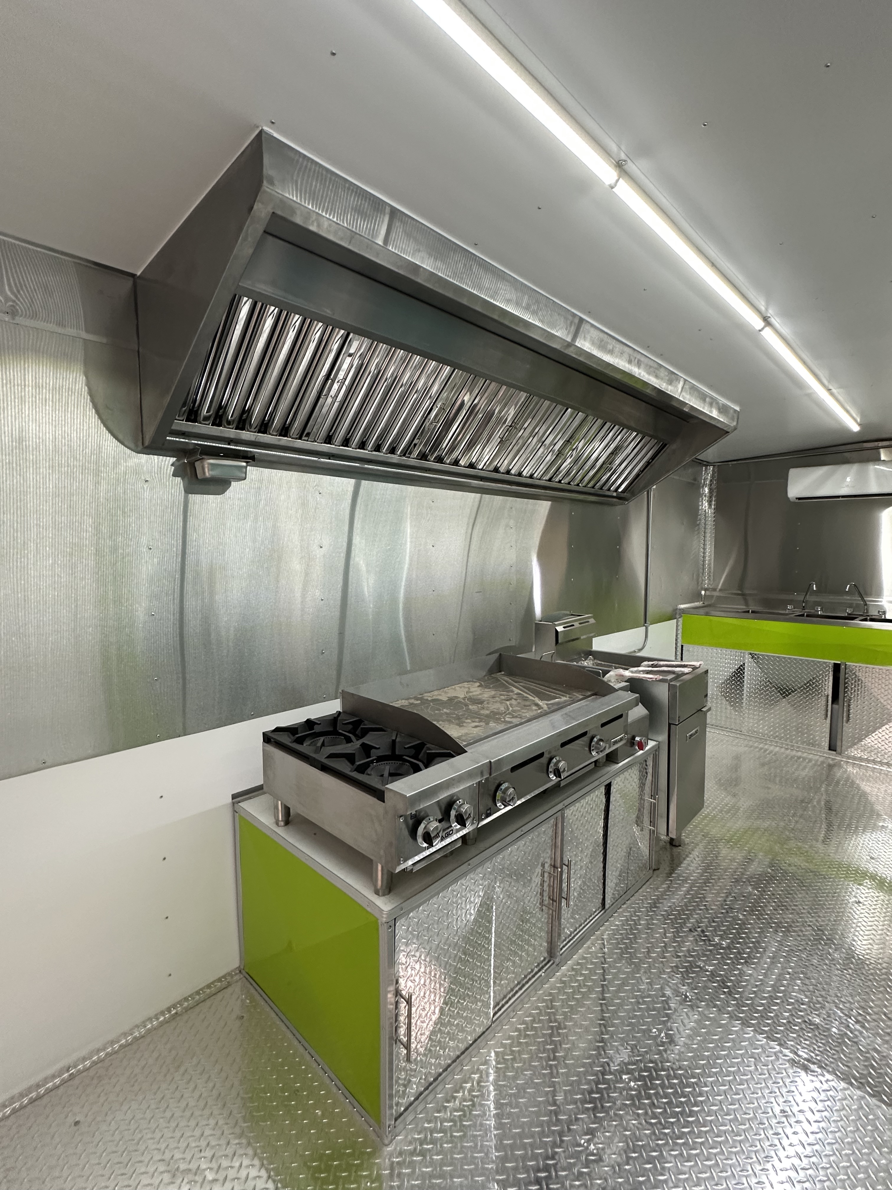 Food trailer interior showing griddle, fryer and prep stations